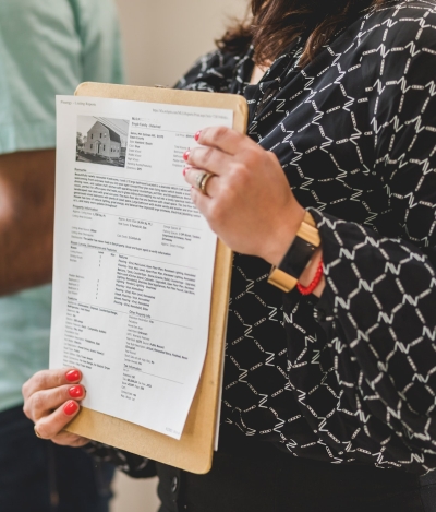 REALTOR sosteniendo una copia impresa en sus manos de una oferta del MLS REALTOR sosteniendo una copia impresa en sus manos de una oferta del MLS