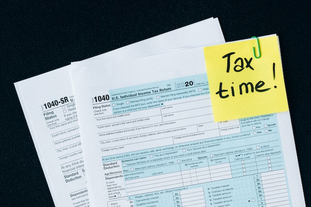 Formulario de declaración de impuestos con una nota amarilla que dice Tax time adjunta en la esquina superior derecha Formulario de declaración de impuestos con una nota amarilla que dice Tax time adjunta en la esquina superior derecha